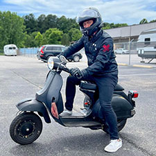 Scooterist posing on a 1979 Vespa P200 before a ride